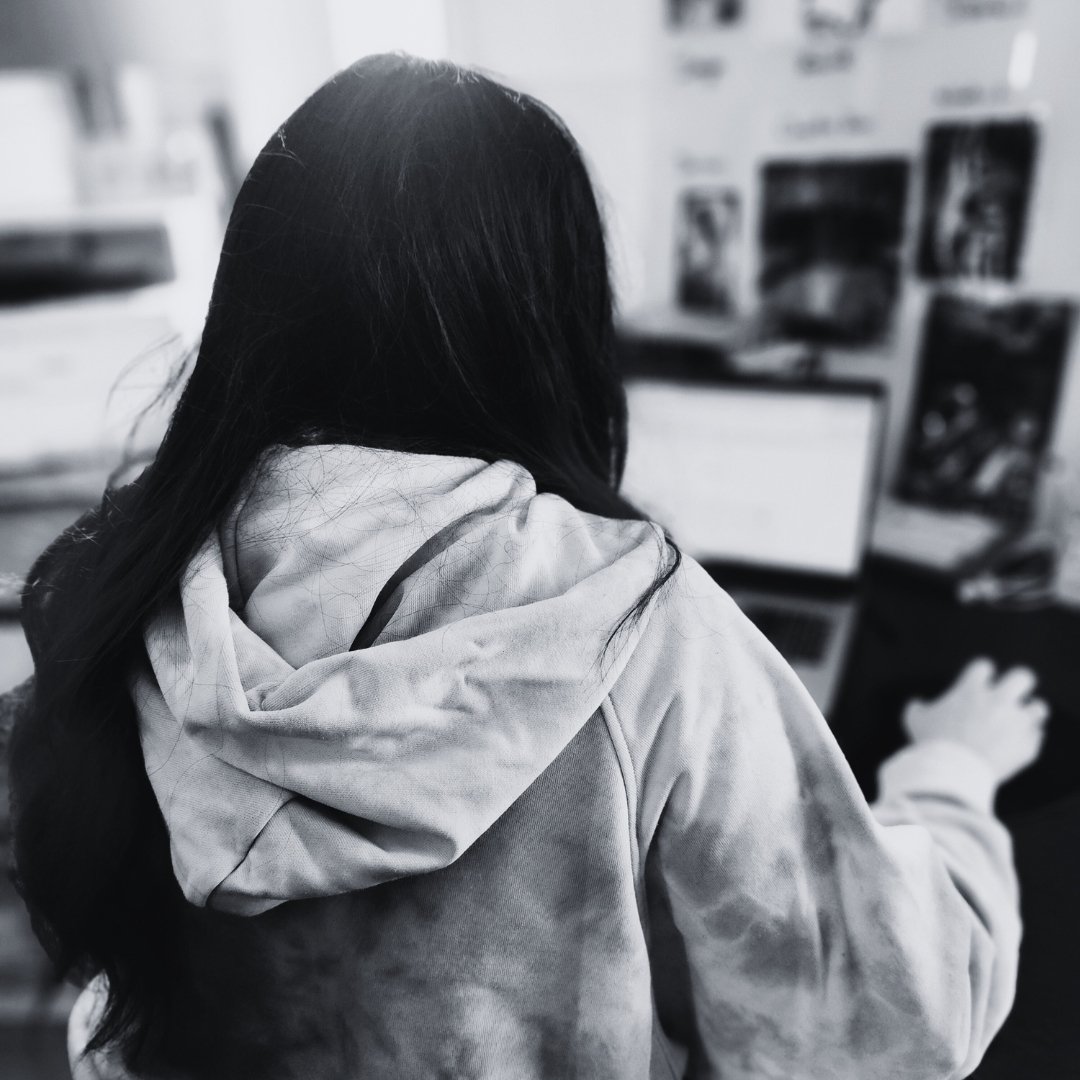 Autrice Eden James de dos, concentrée sur son écran dans son univers d’écriture.